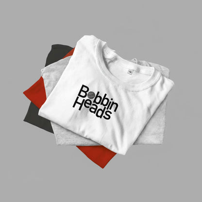Folded white t-shirt with 'Bobbin Heads' logo on a gray background