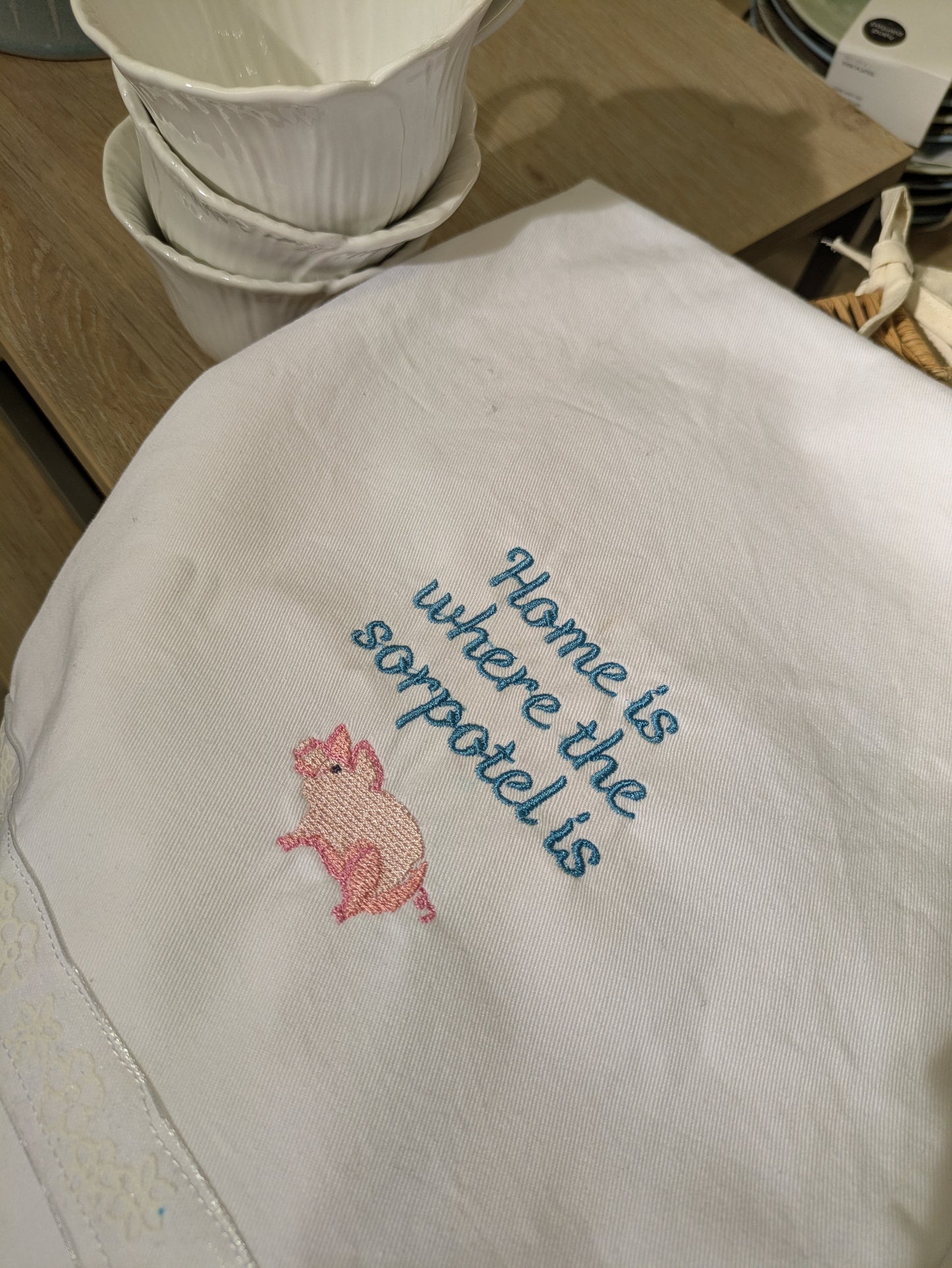 Embroidered towel with a pink pig and text on a white background