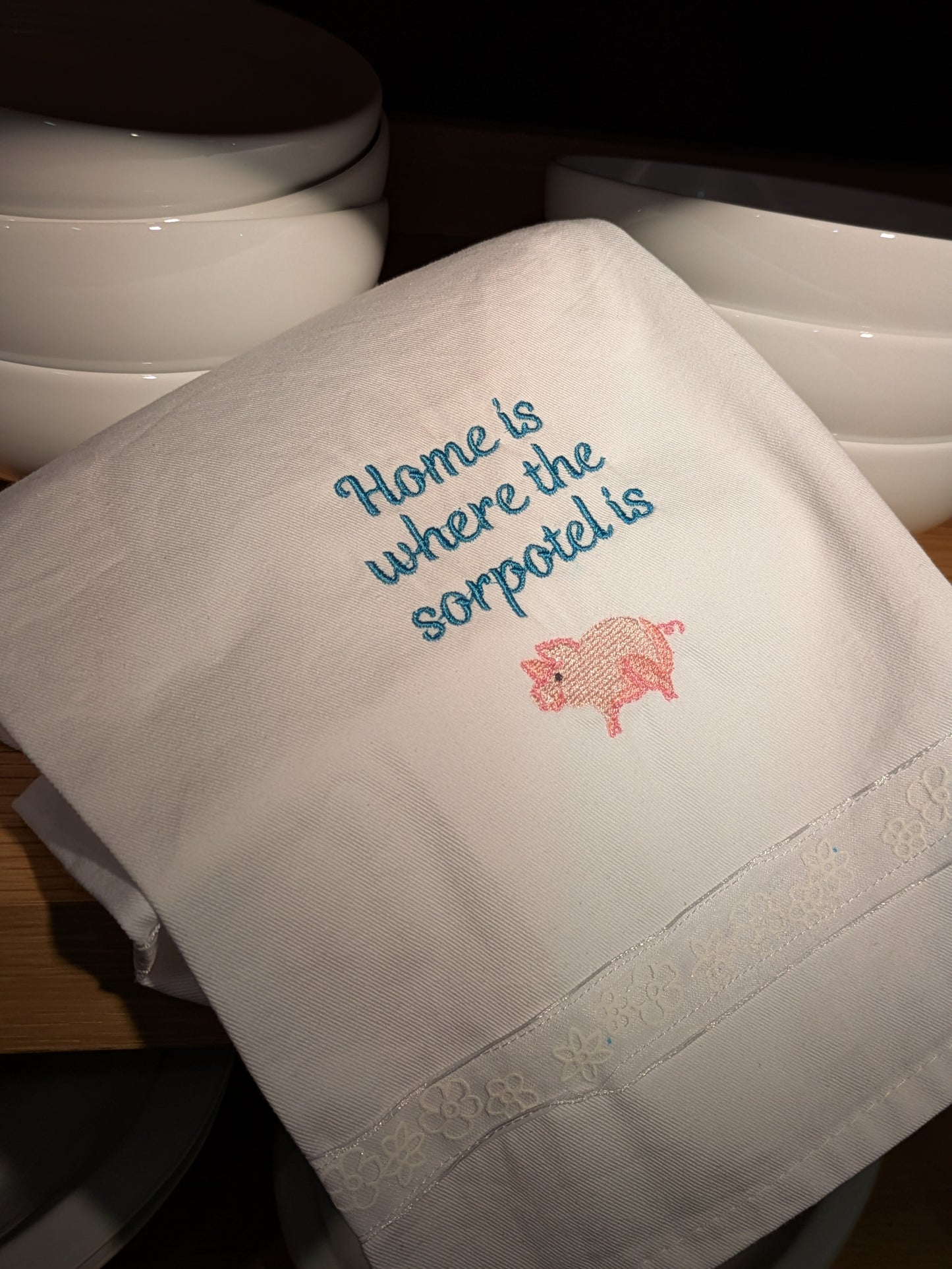Embroidered towel with text and pig design on a white background